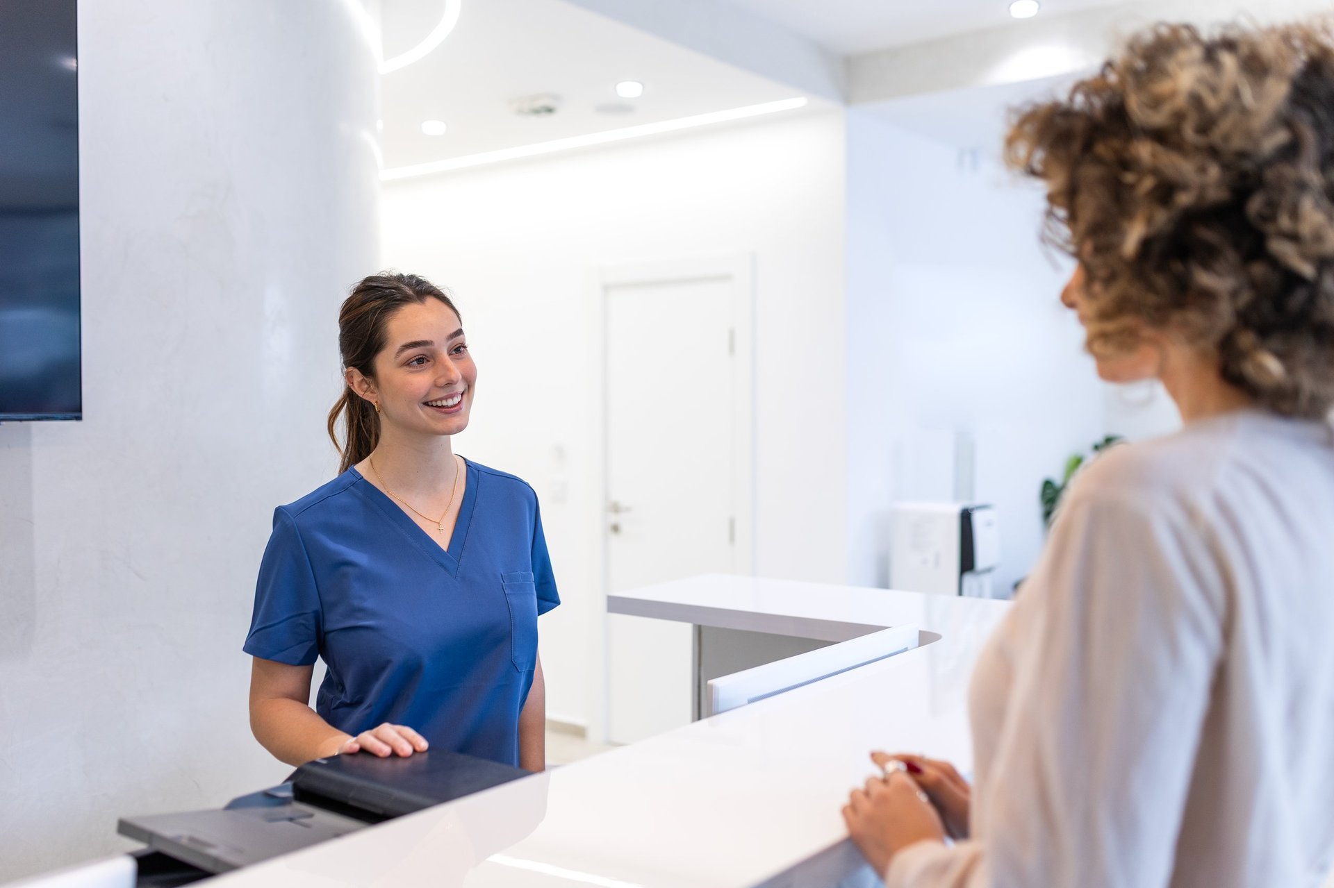 Friendly medical professional welcoming a patient in a modern clinic reception